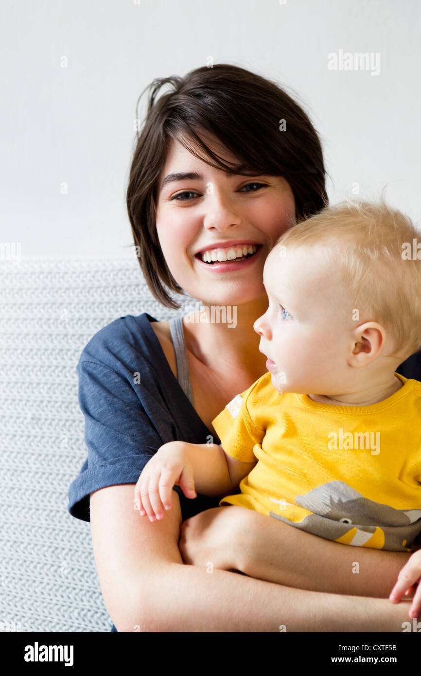 Mother and baby sitting on bed Stock Photo Alamy