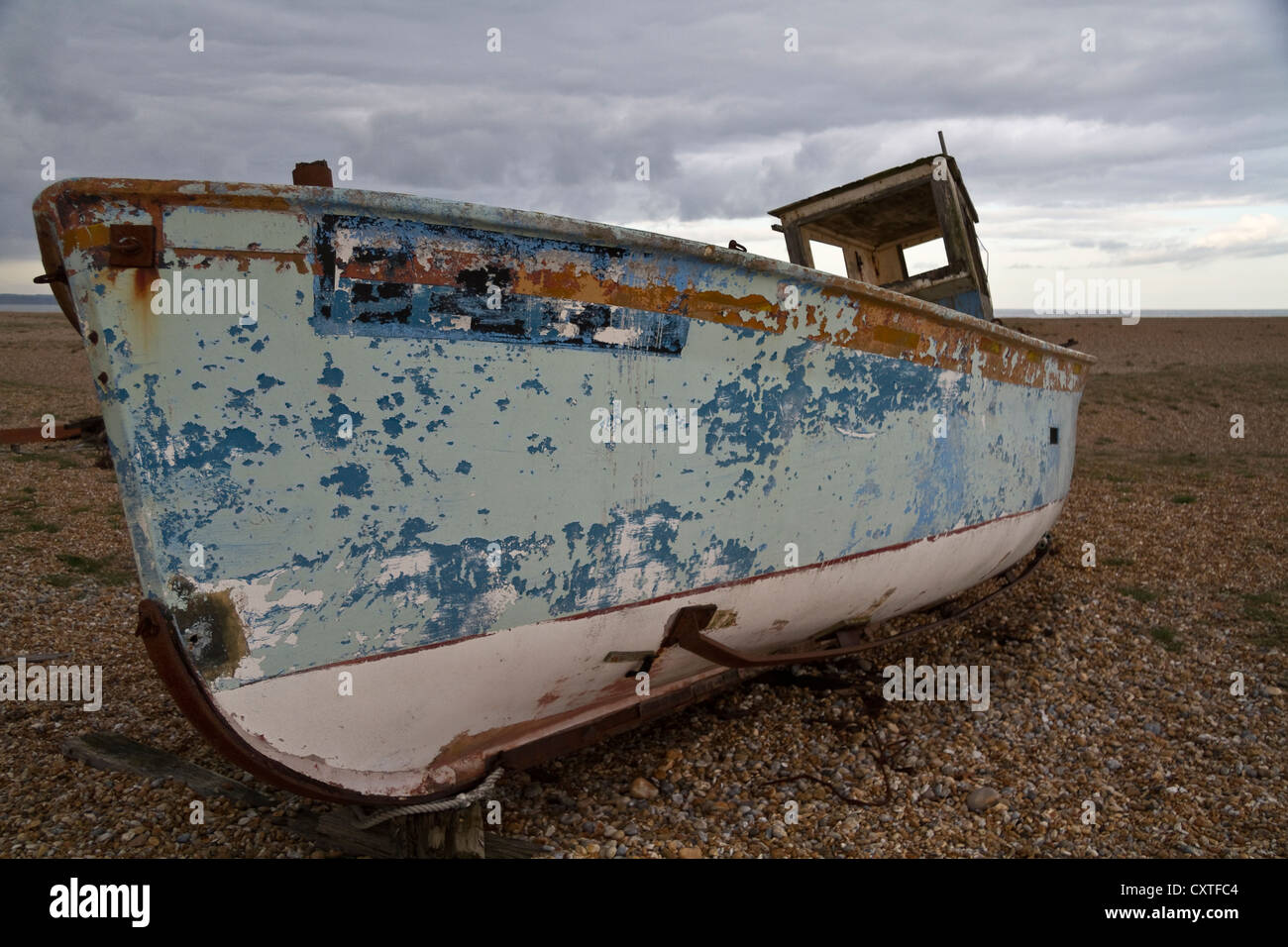 An abandoned fishing boat on a pebble beach Stock Photo - Alamy