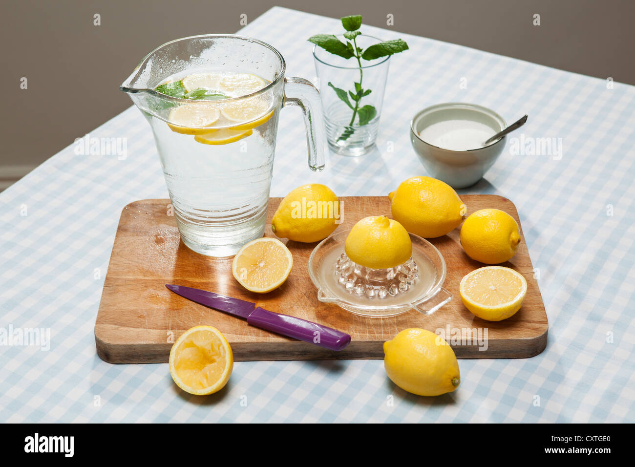 Lemons, juicer and pitcher of water Stock Photo Alamy