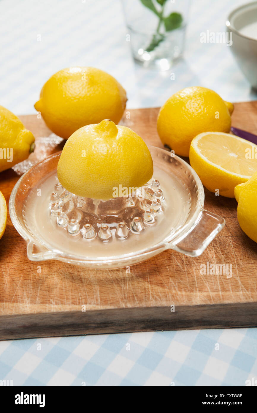Lemons, juicer and pitcher of water Stock Photo Alamy