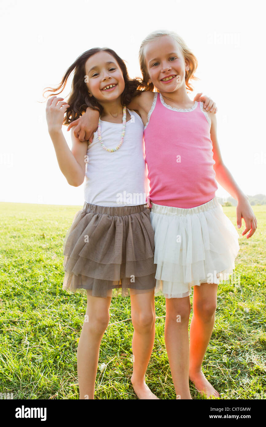 Smiling girls hugging outdoors Stock Photo - Alamy