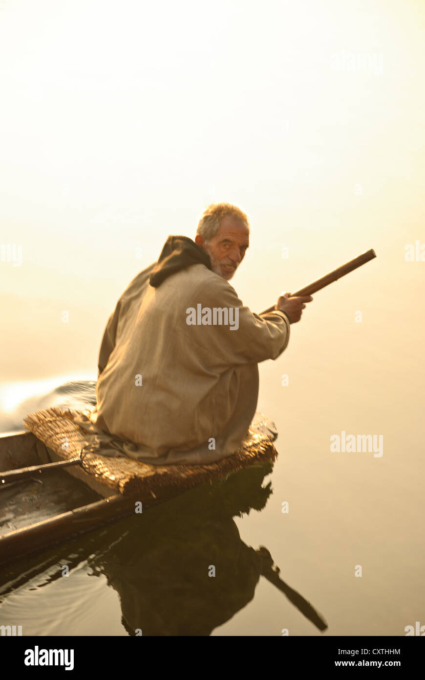 Local villager paddle his boat in Nagin Lake, Srinagar, early morning Stock Photo