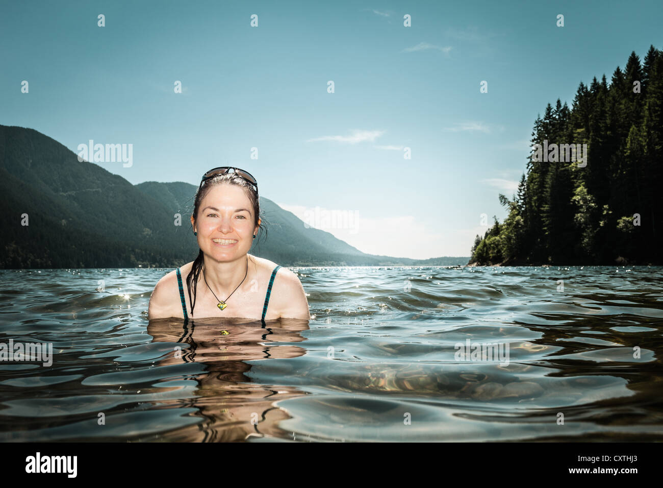 Woman standing in still lake Stock Photo
