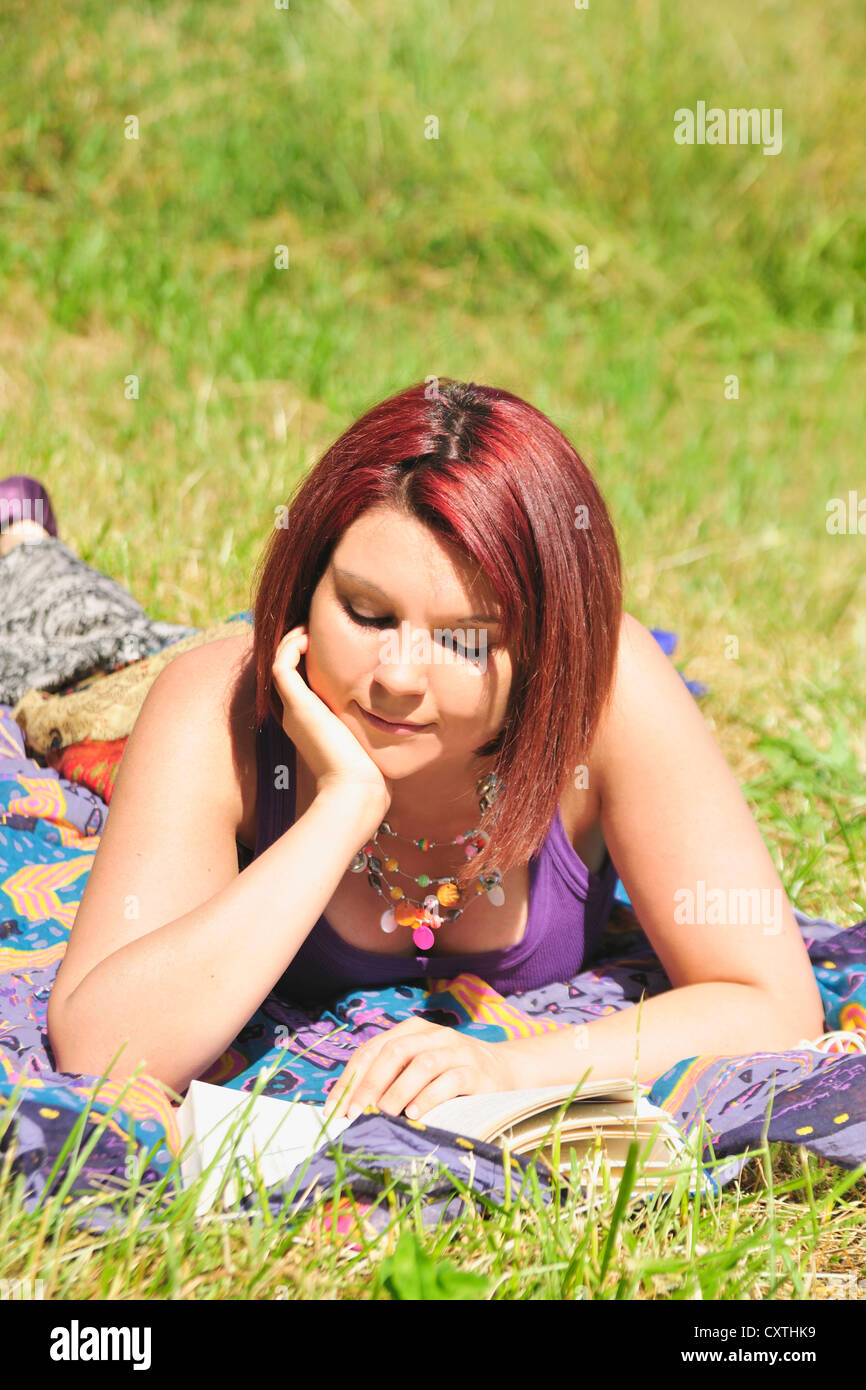 Woman reading book in grass Stock Photo