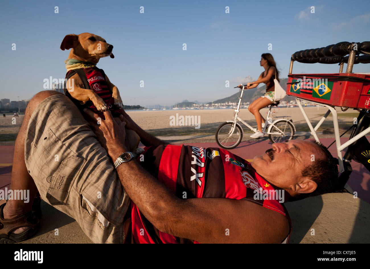 Man and Dog in Flamengo Football Team Shirts infront of Botafogo Beach Rio de Janeiro Brazil Stock Photo