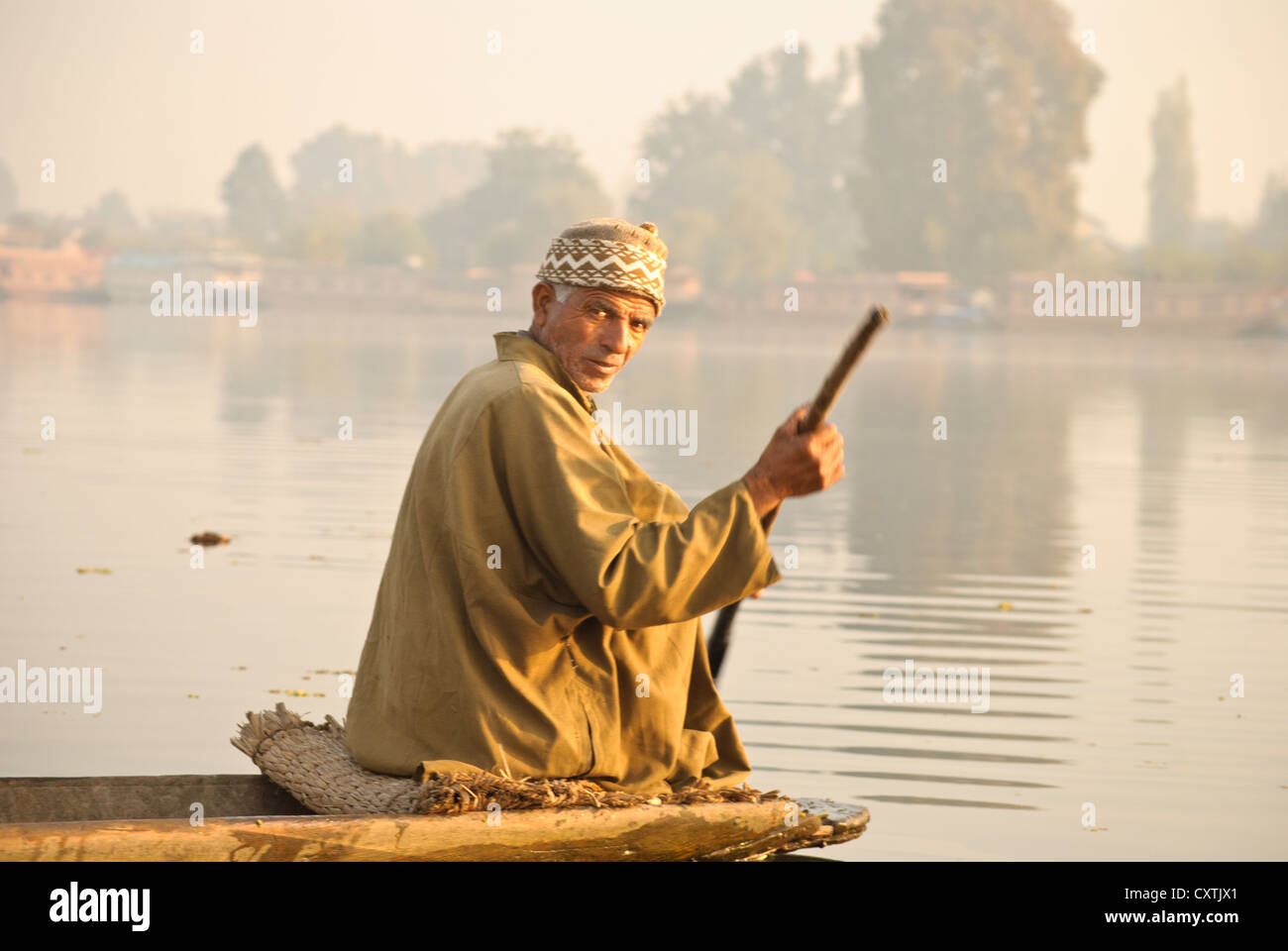 A local man paddling his boat in Nagin Lake, Srinagar. Stock Photo
