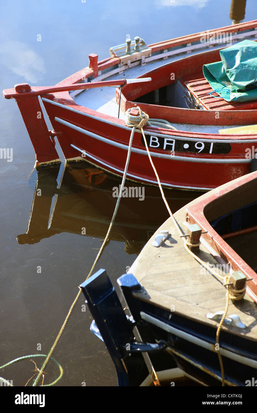 Red and blue painted boats in a Scottish Harbour Stock Photo