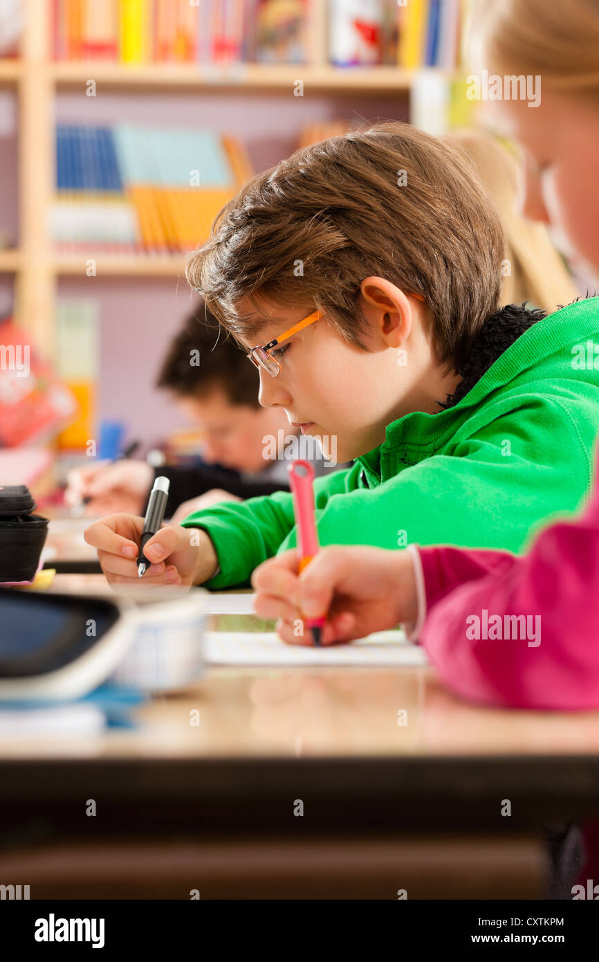 Education - Pupils at primary or elementary school doing their homework or having a school test Stock Photo
