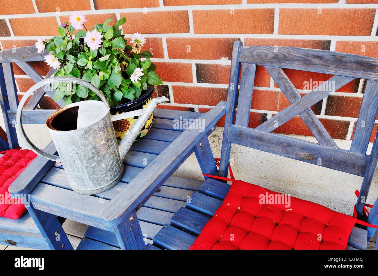 watering can and flower pot on the table against brick wall Stock Photo ...