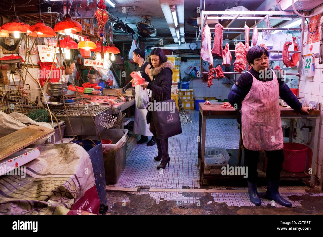 Butchers in Hong Kong's Central Market prepare cuts of meat during a