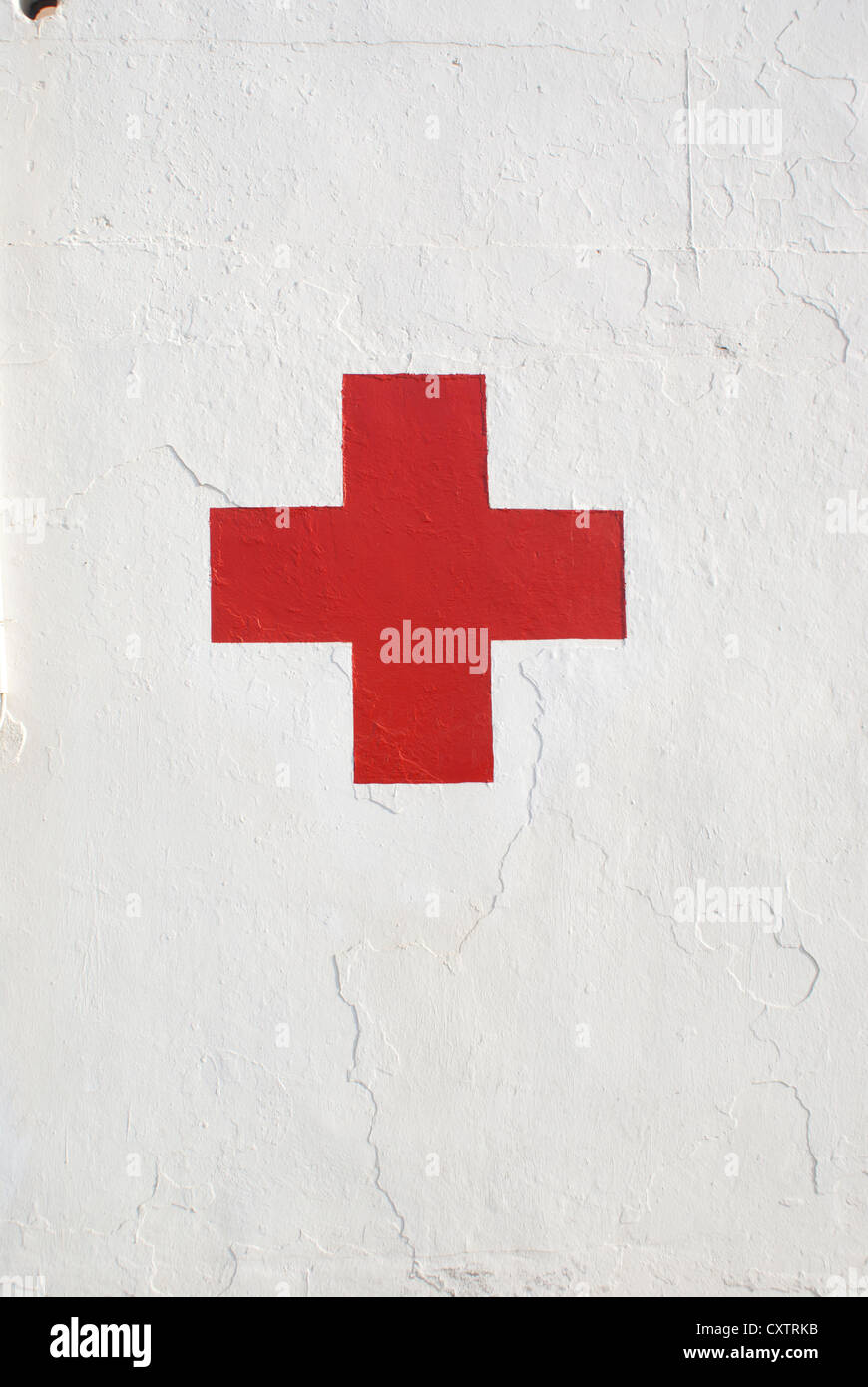 Red cross symbol on white wall Stock Photo