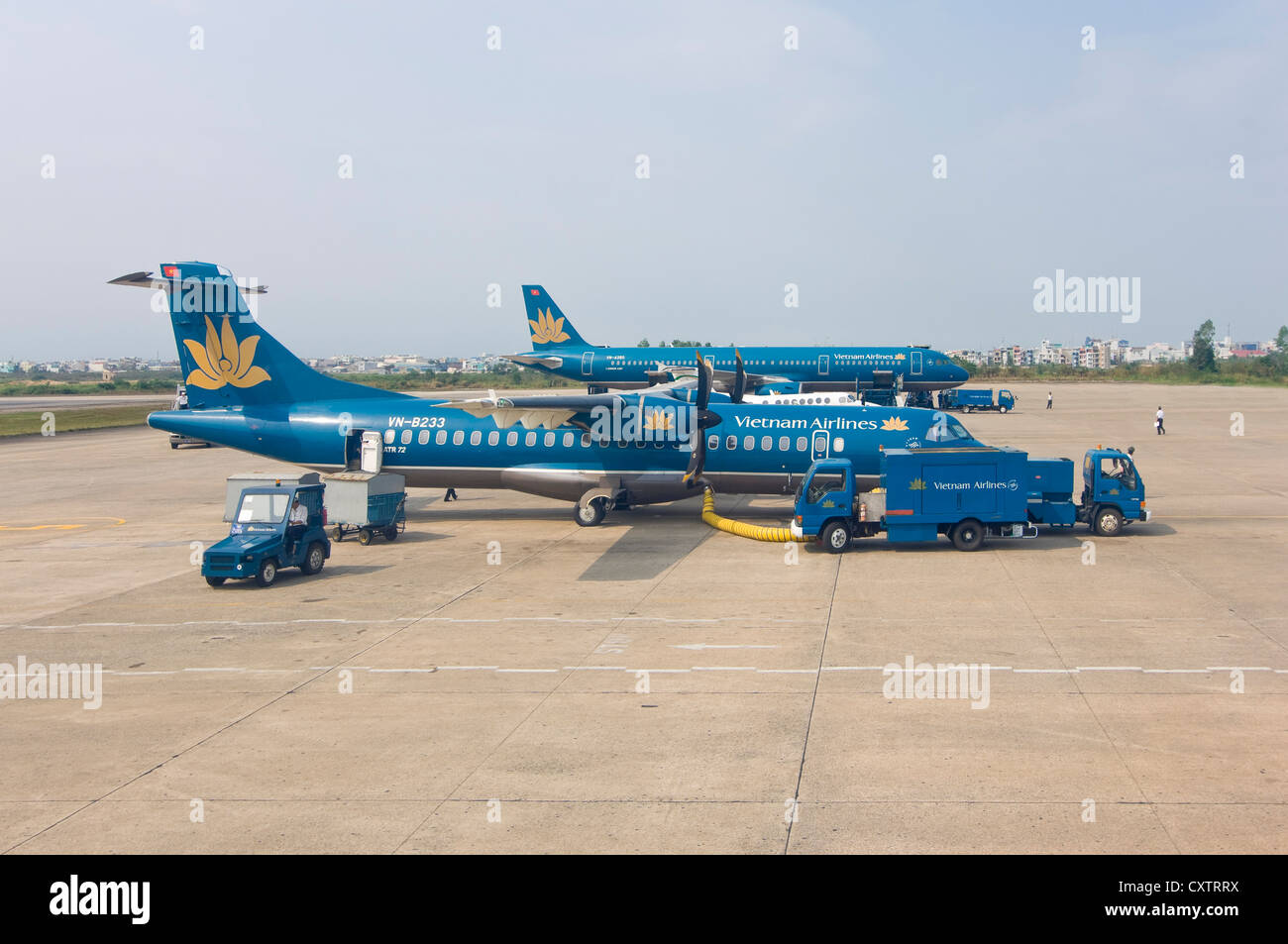 Horizontal view of two Vietnamese Airline planes, an ATR 72-212A twin propelled and an Airbus A320, refuelling at the airport. Stock Photo