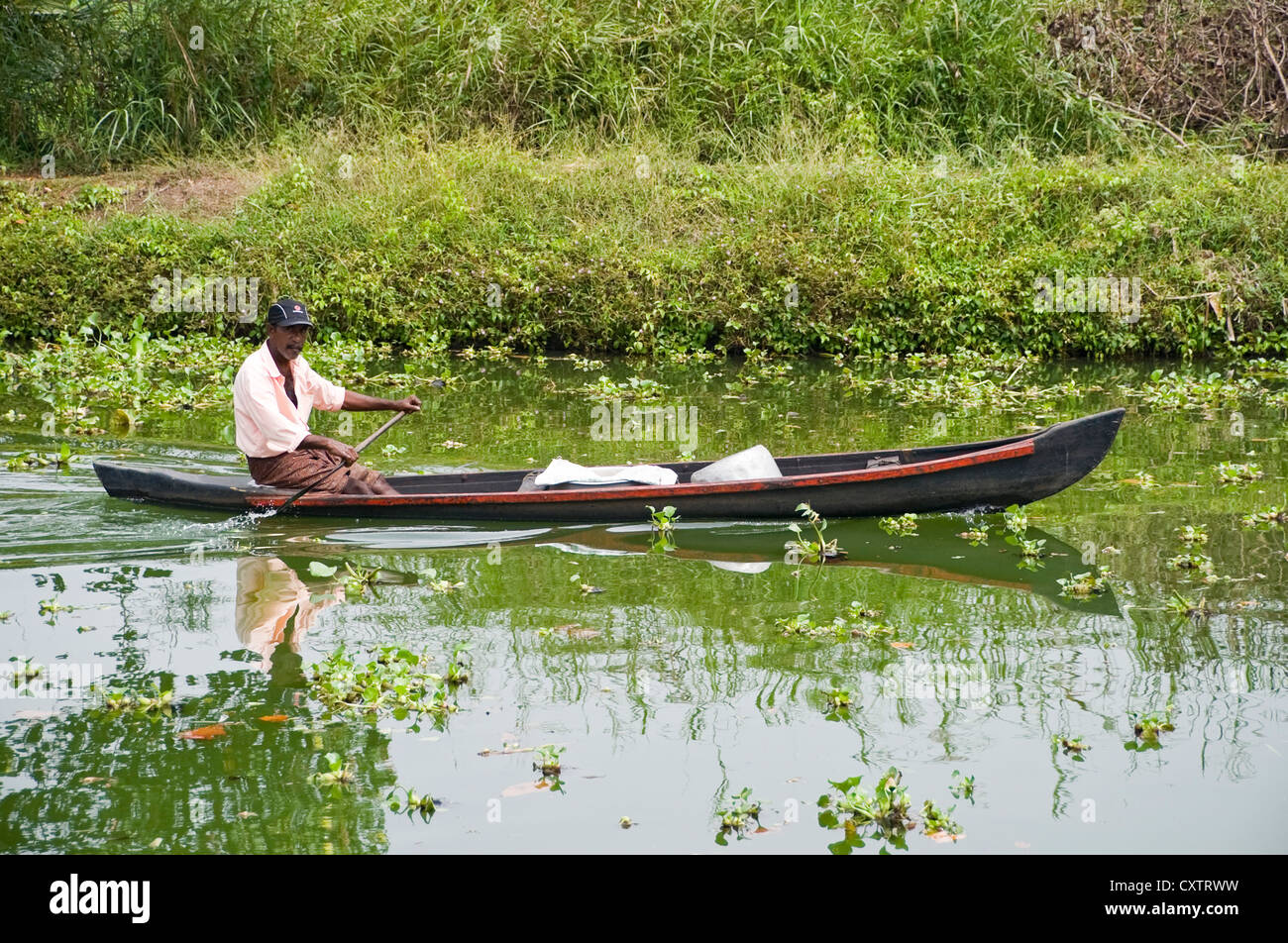 Horizontal view of traditional fishermen and his fishing boat on the backwaters of Kerala. Stock Photo