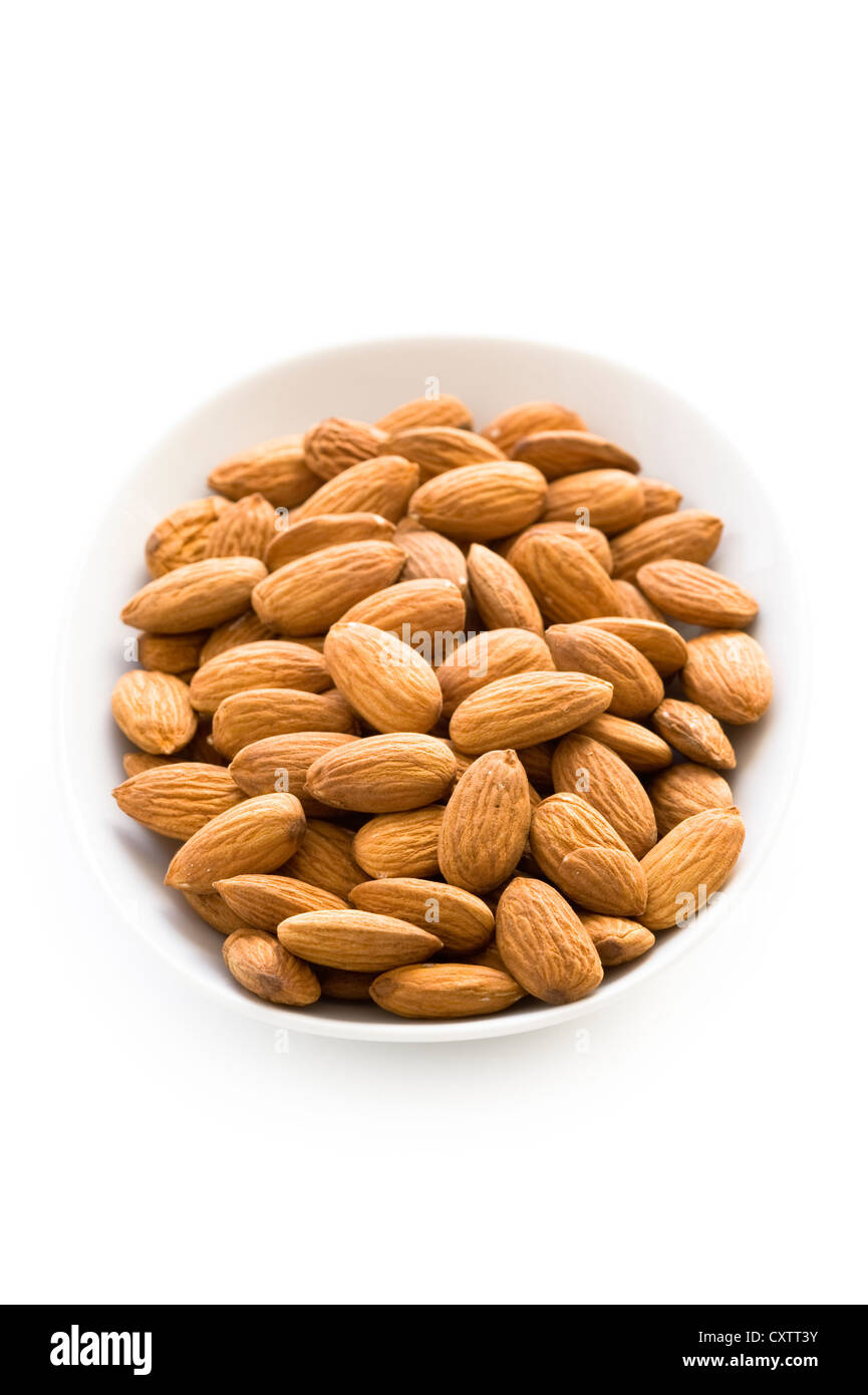 whole shelled almond nuts or almonds in a dish, bowl or plate isolated on a white background cutout Stock Photo