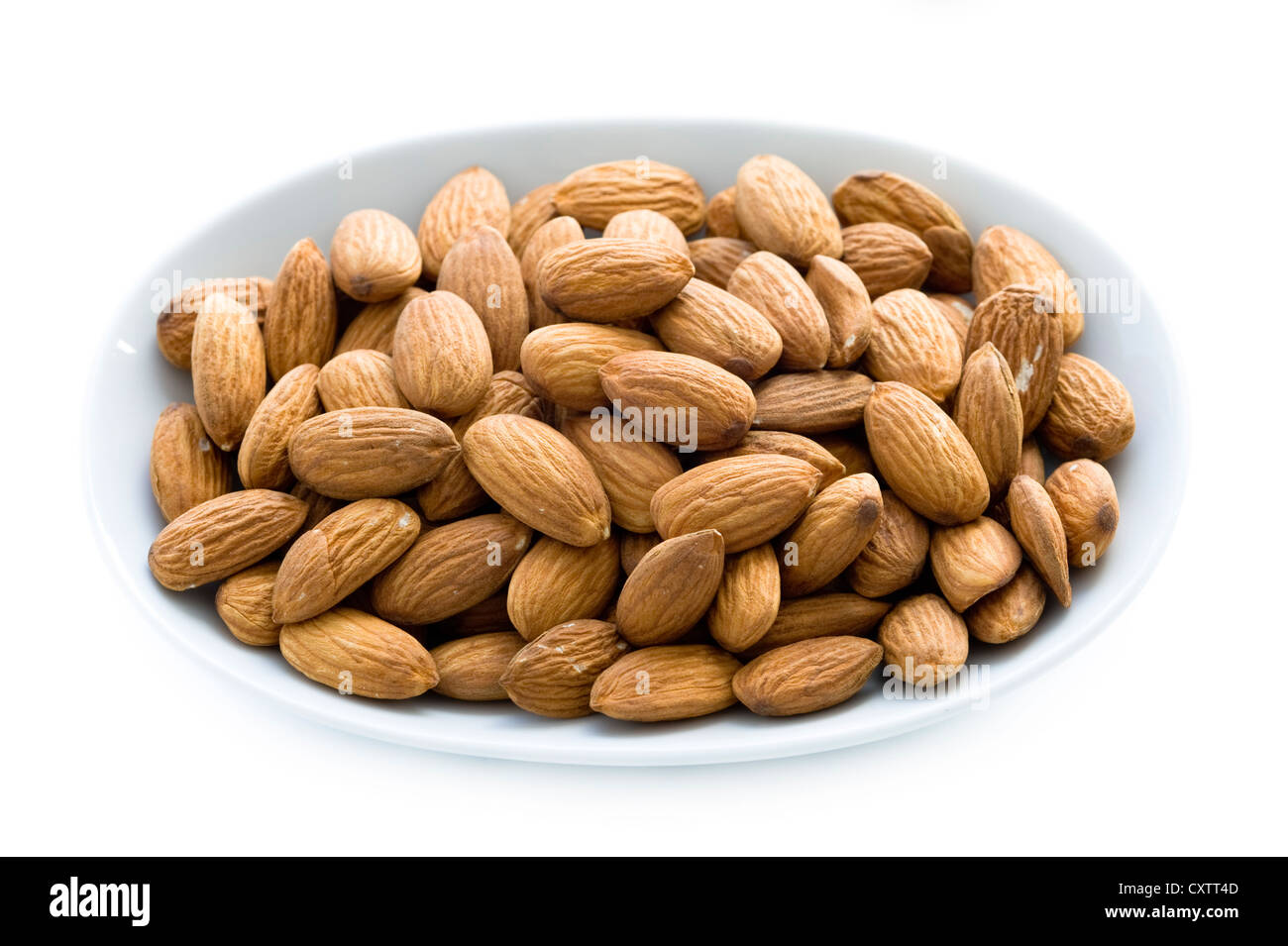 whole shelled almond nuts or almonds in a dish, bowl or plate isolated on a white background cutout Stock Photo