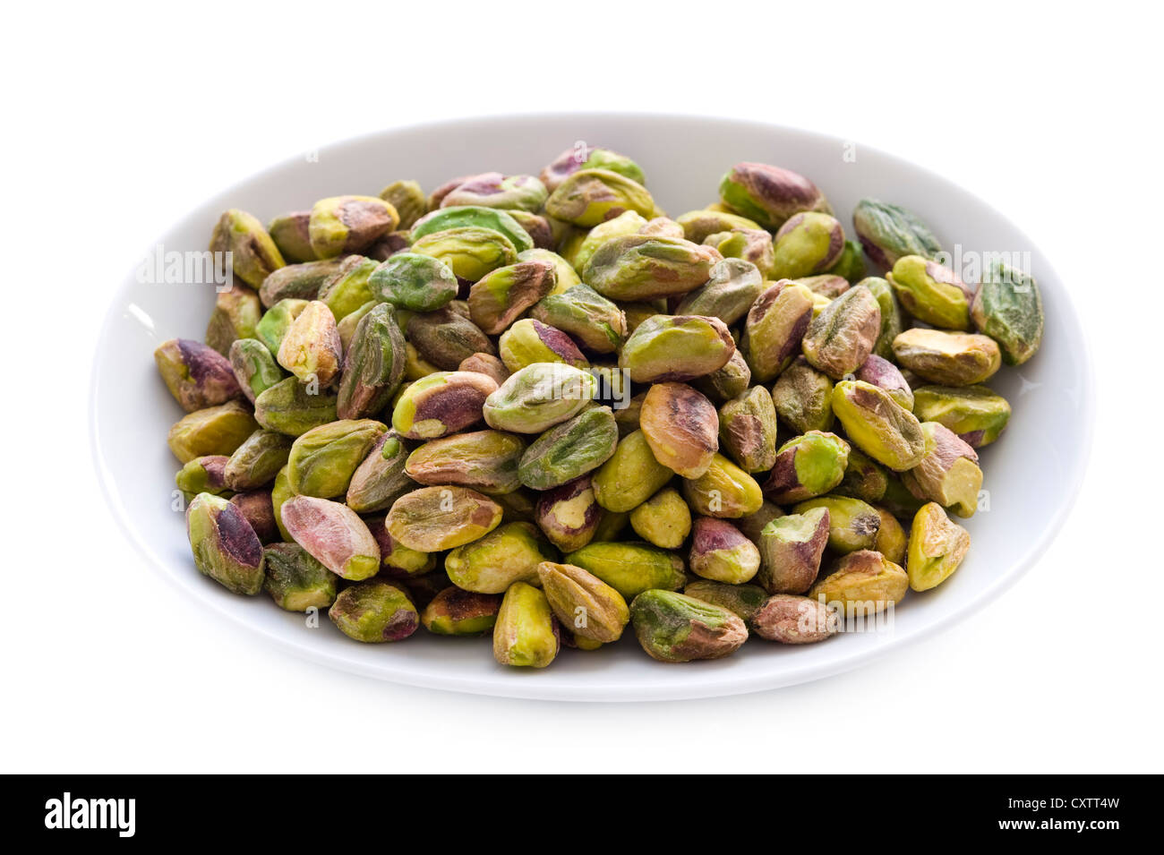 whole shelled pistachio nuts in a bowl isolated on a white background Stock Photo