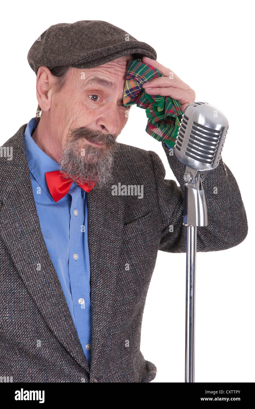 tired elderly host with microphone wiping forehead Stock Photo