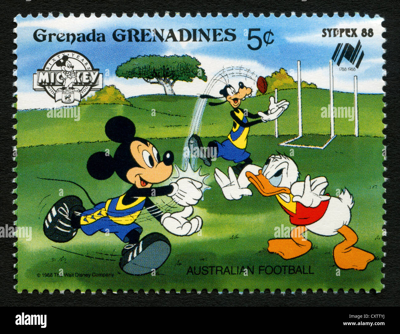Grenada postage stamp - Disney cartoon characters - Mickey Mouse, Goofy and Donald Duck playing Australian football Stock Photo