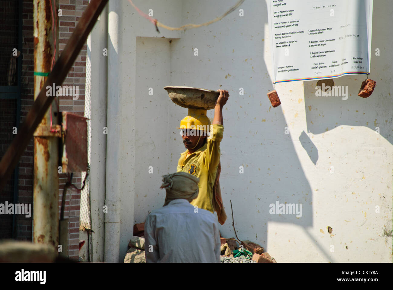 Construction worker carrying materials on his head Stock Photo Alamy