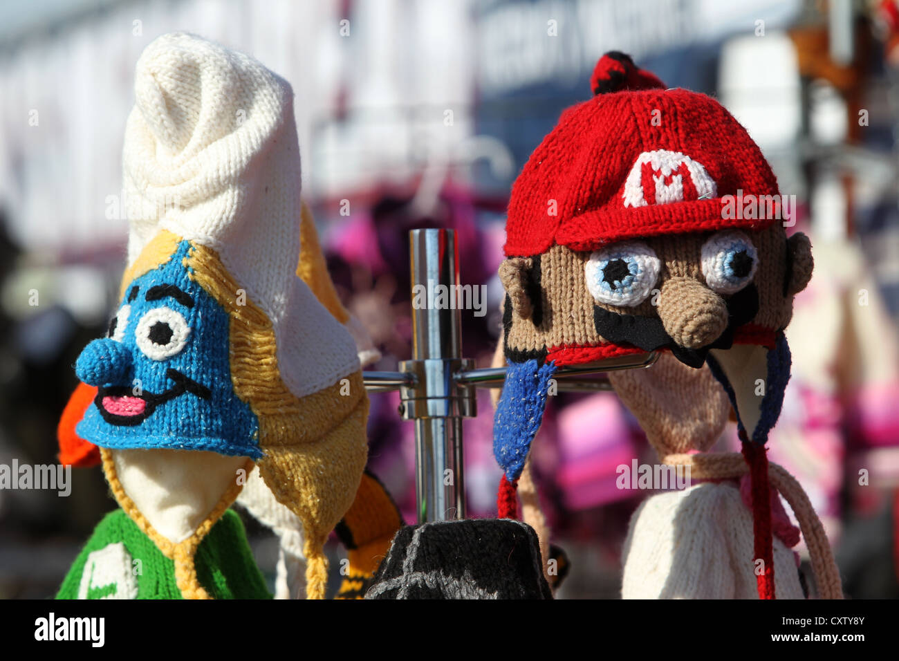 Hand made knitted hats in the style of a Smirf and Mario characters for sale on a stall in Brighton, East Sussex, UK. Stock Photo