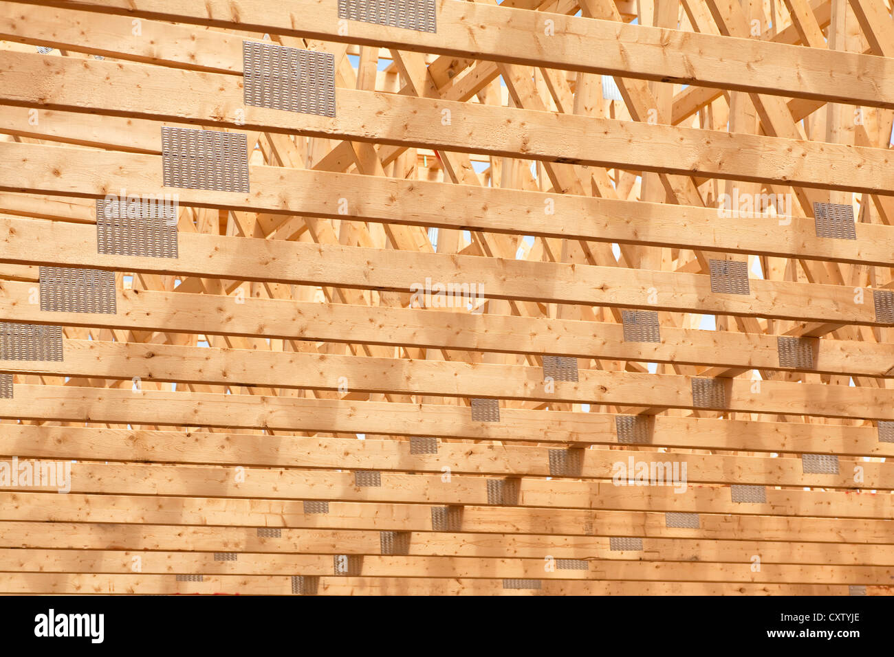 Roof rafters in the new construction of a wooden building or house. Stock Photo