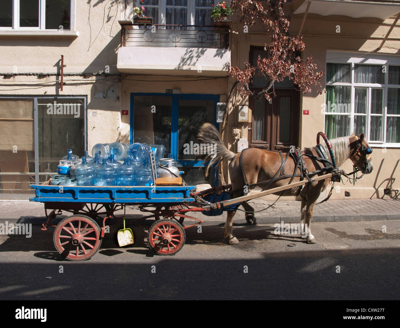 Horse drawn wagon / cart for goods transportation in Buyukada Turkey filled with fresh water tanks Stock Photo