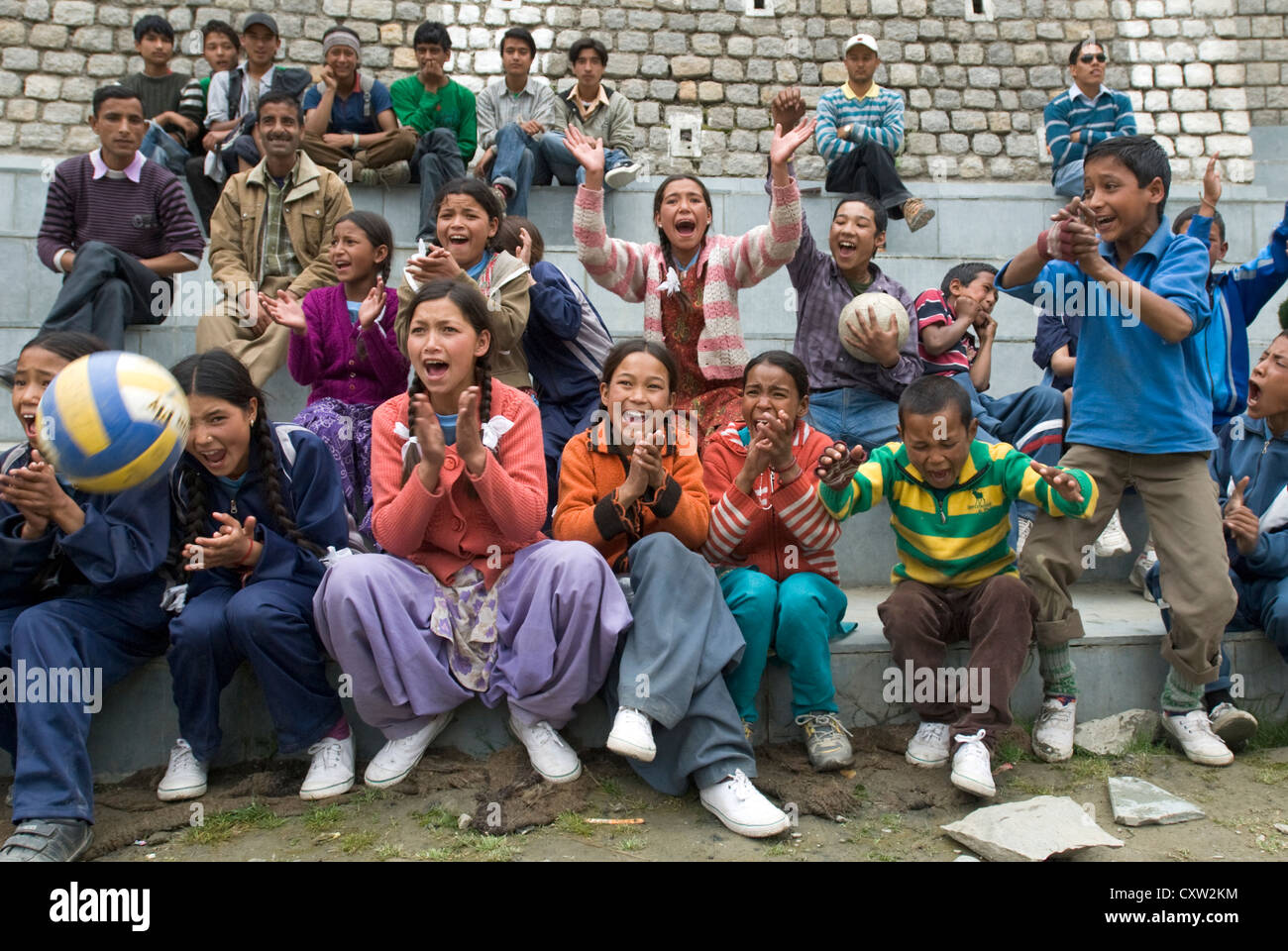 Spectators clap and cheer the winning point in a volleyball match