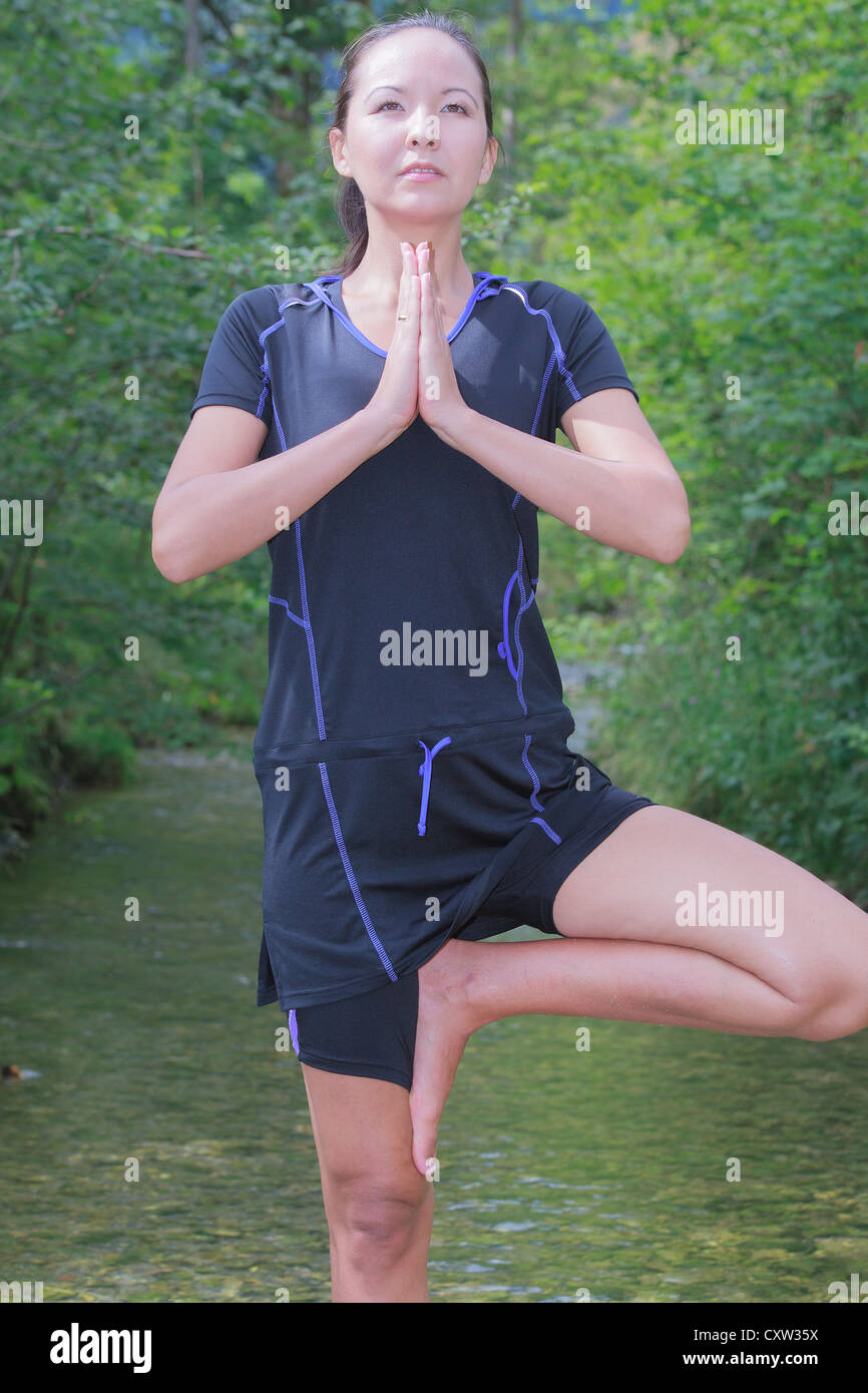 Woman doing yoga in the flowing waters Stock Photo