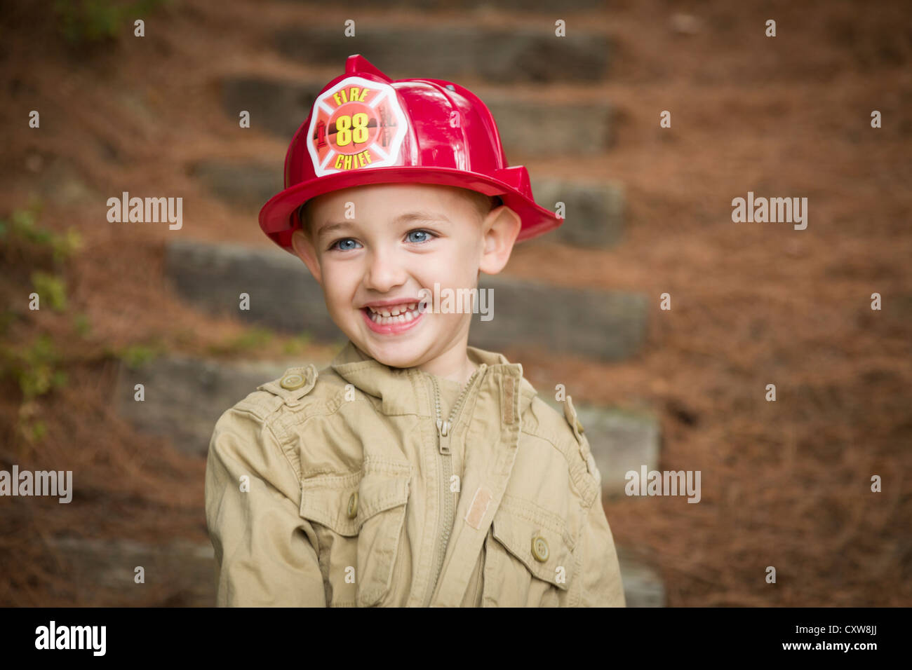 Happy Adorable Child Boy with Fireman Hat Playing Outside. Stock Photo