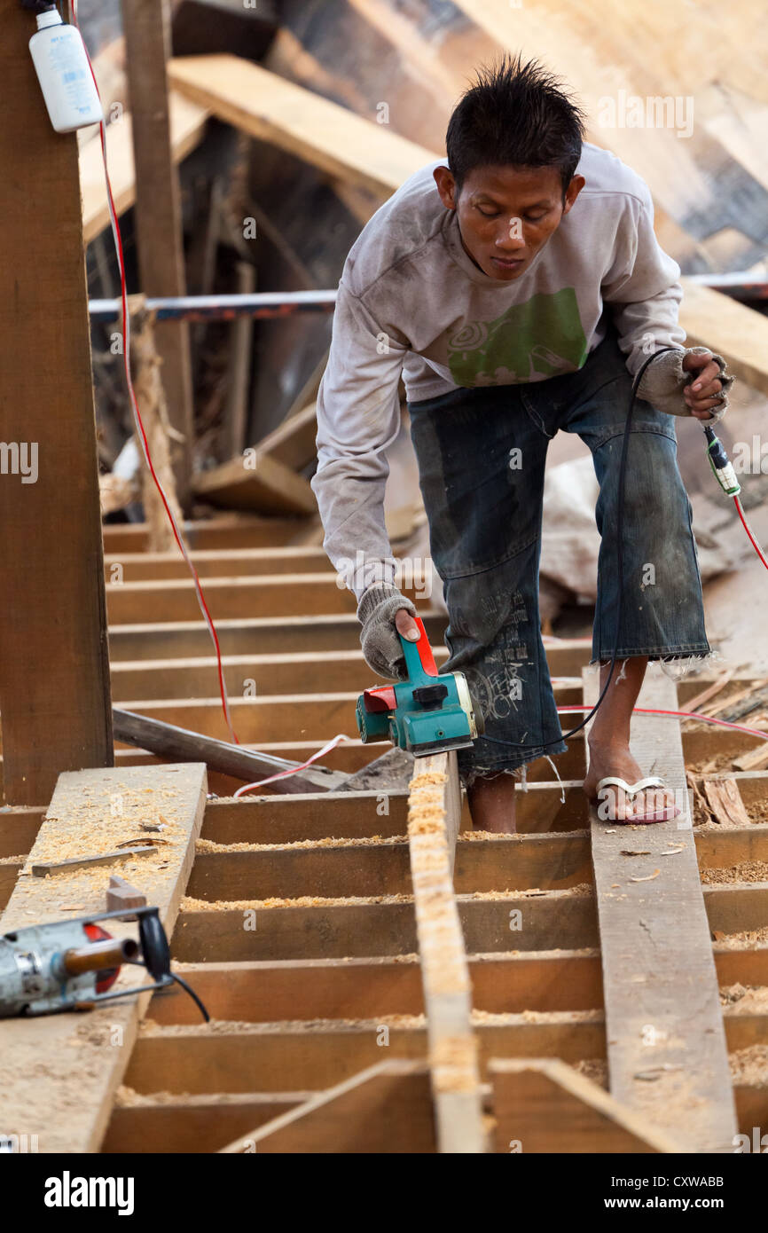 Boat Builder on a traditional Shipyard for River Boats in Banjarmasin, Kalimantan, Indonesia Stock Photo