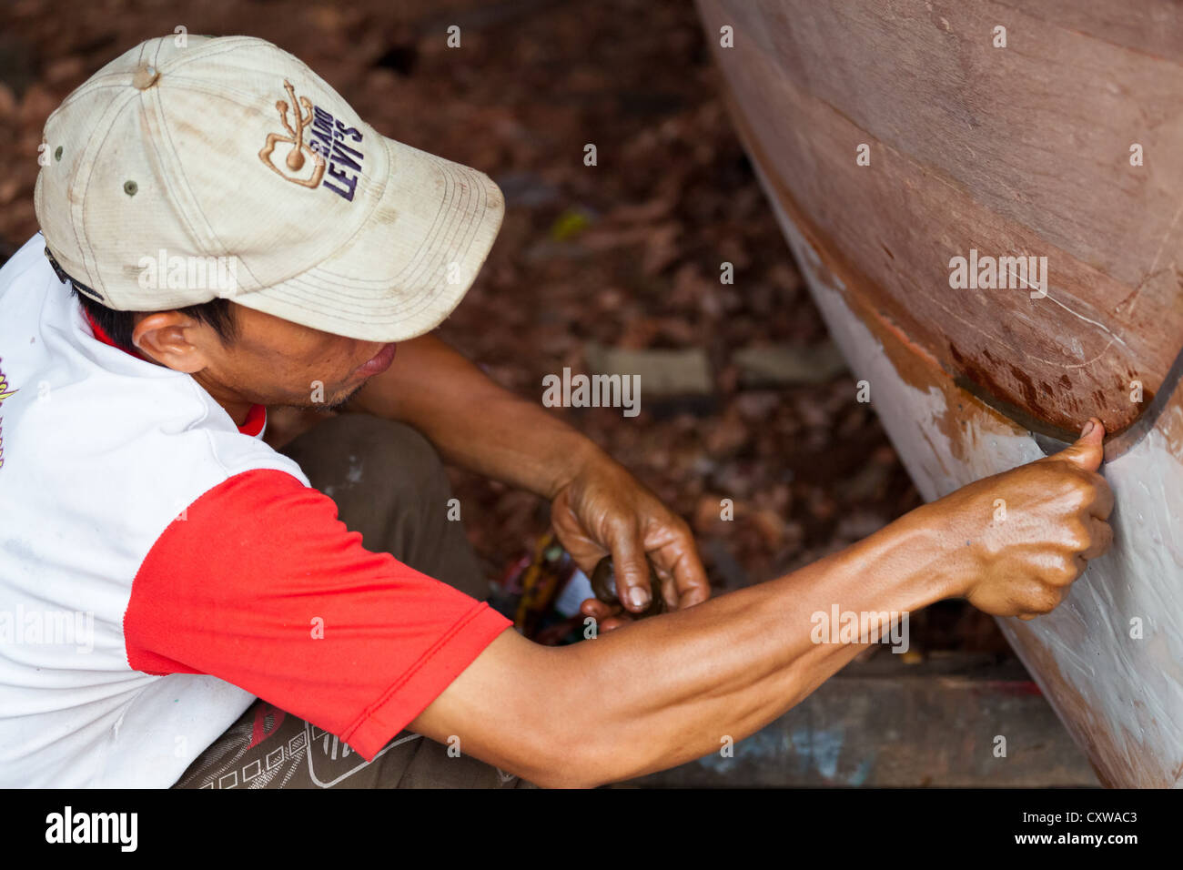 Boat Builder on a traditional Shipyard for River Boats in Banjarmasin, Kalimantan, Indonesia Stock Photo