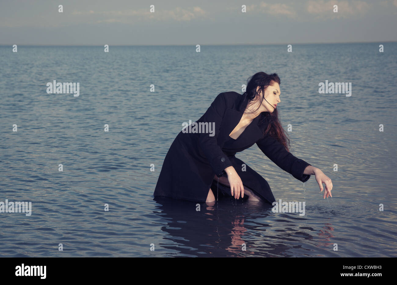Lady in wet coat dancing in the sea Stock Photo Alamy