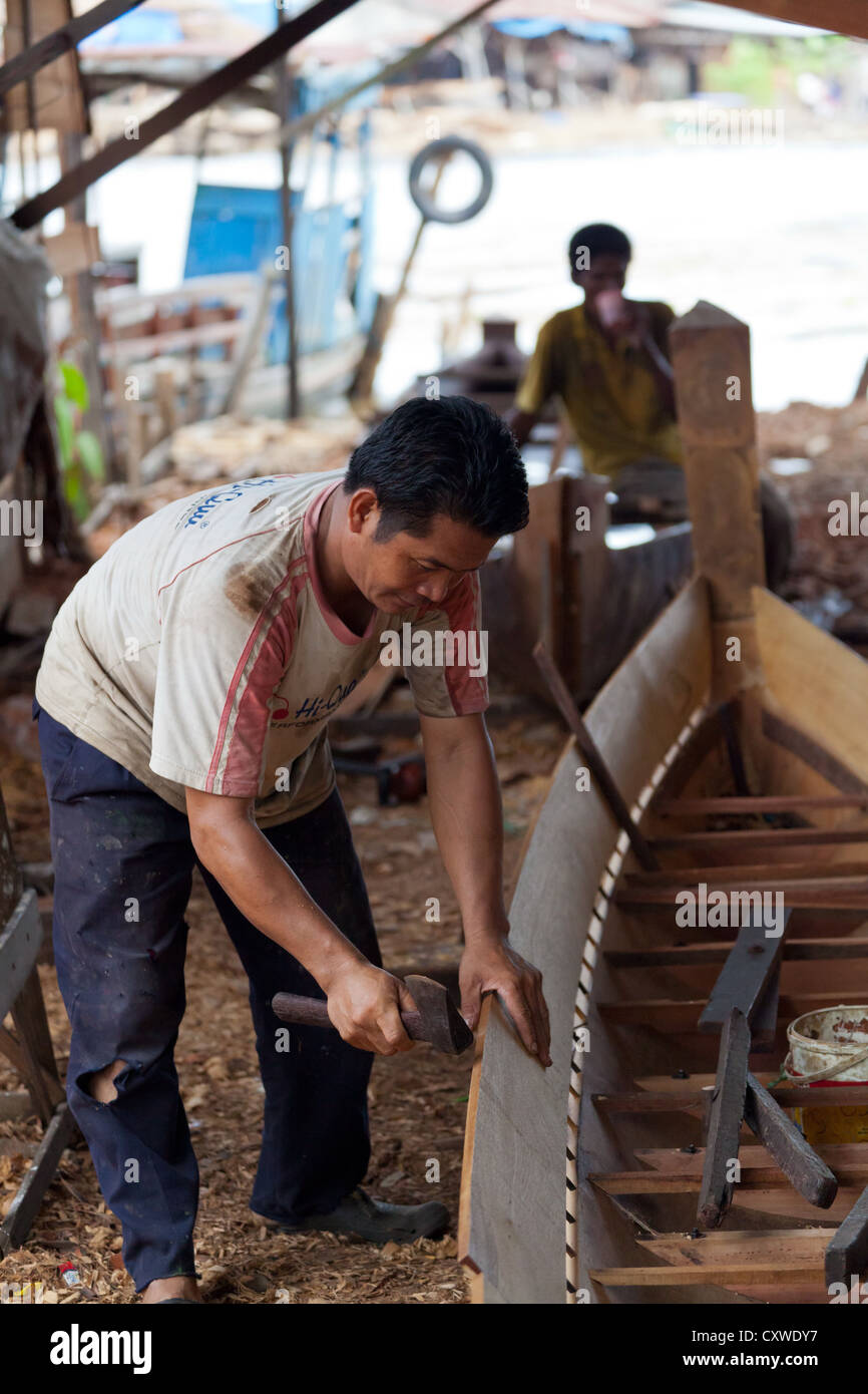 Boat Builder on a traditional Shipyard for River Boats in Banjarmasin, Kalimantan, Indonesia Stock Photo