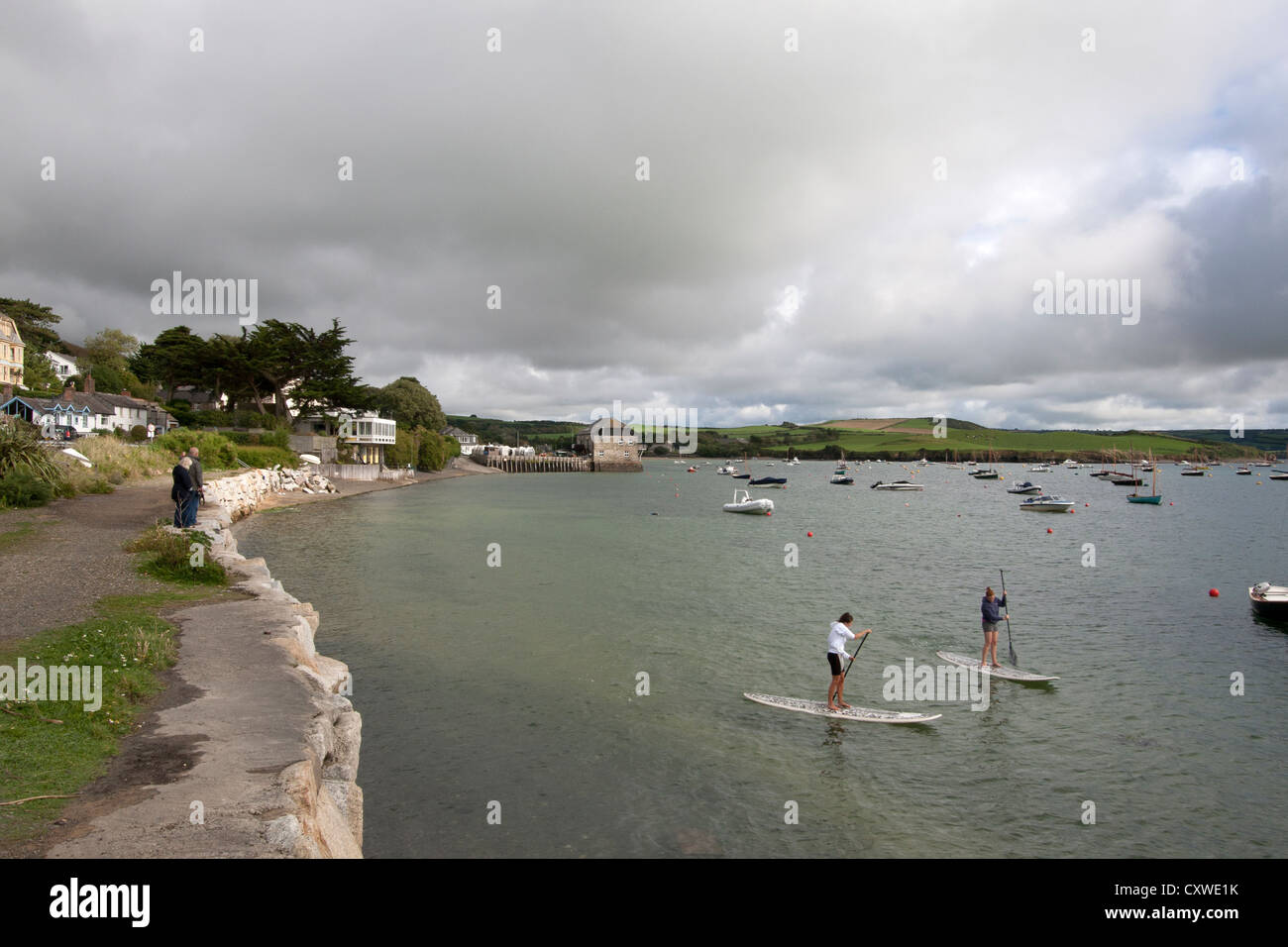 Two young women on stand up paddleboards, Rock, Cornwall, UK Stock Photo