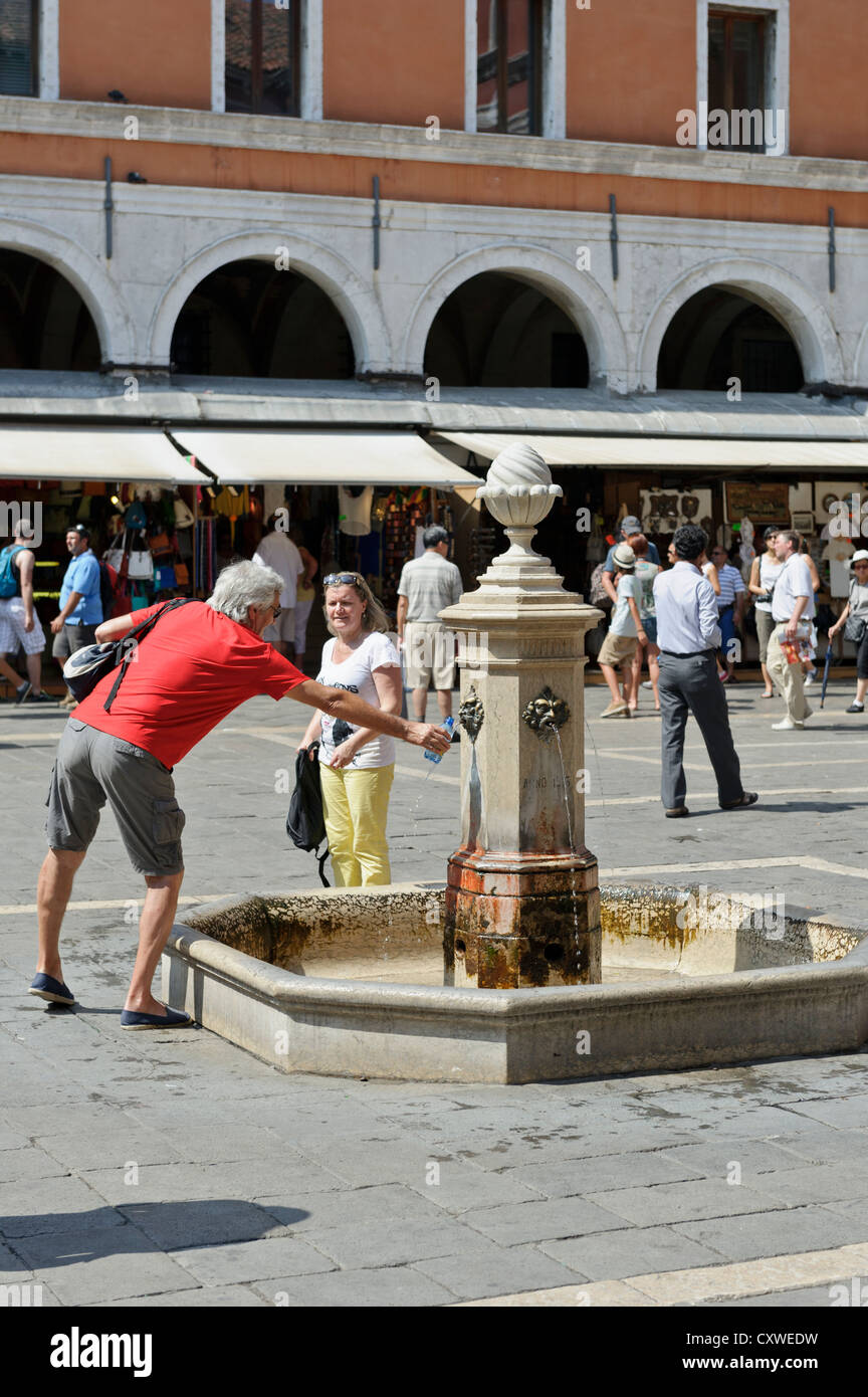 Refilling water bottle at water fountain, Rialto, Venice, Italy Stock