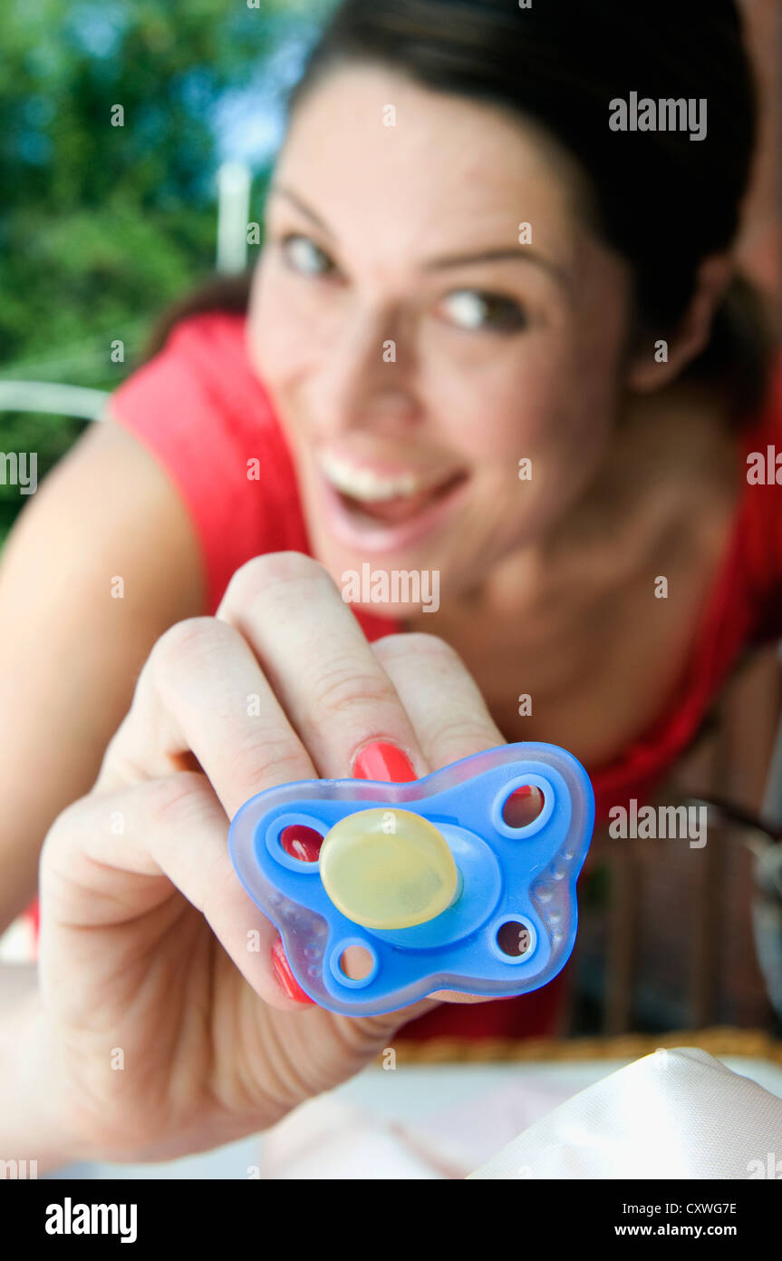 A mother putting offering her child a binky Stock Photo Alamy