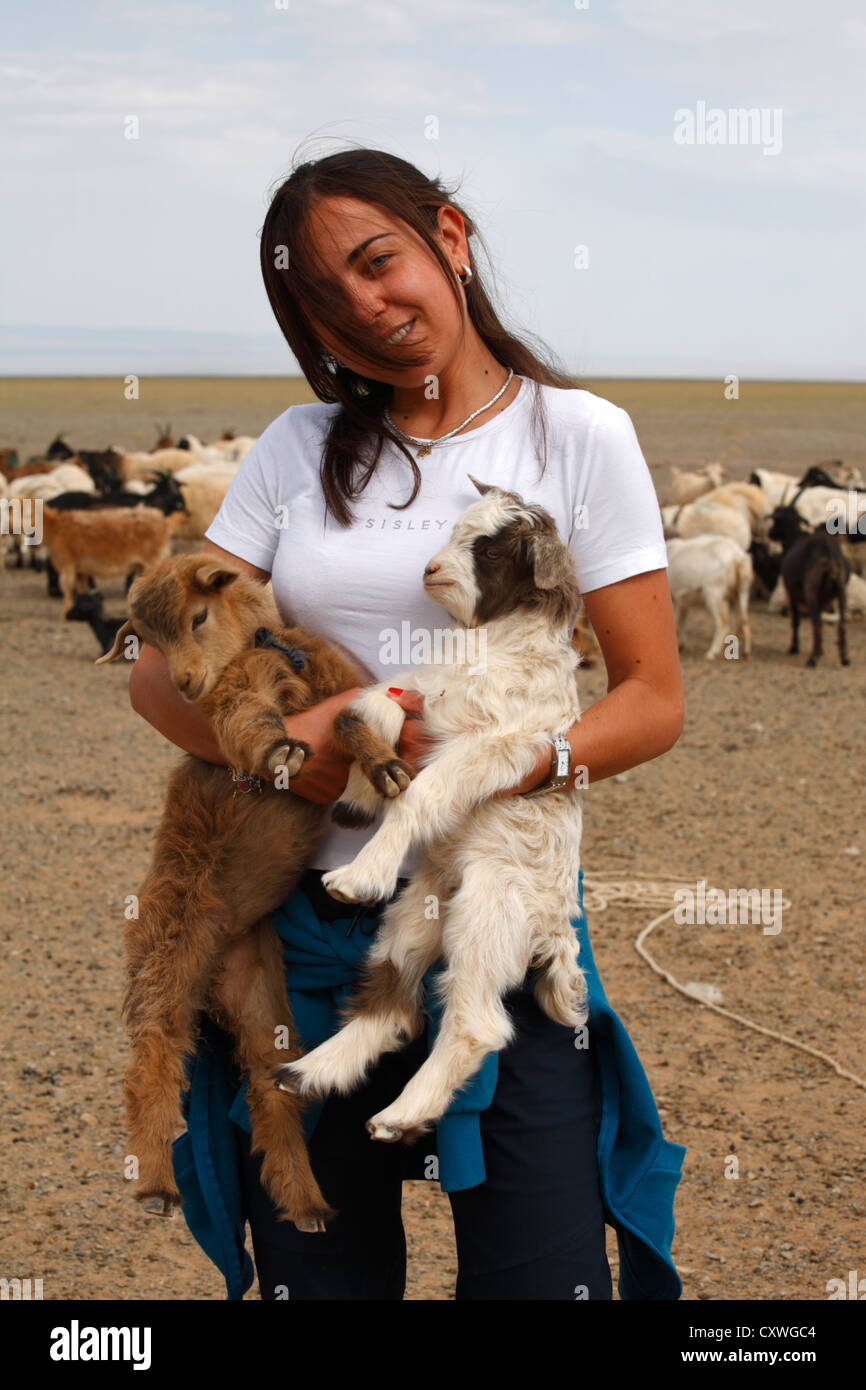 Portrait of caucasian girl holding a lamb in her arms, Mongolia Stock ...
