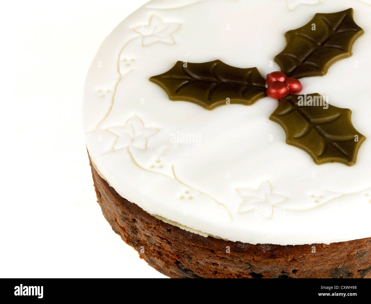 Rich Traditional Festive Christmas Fruit Cake With White Icing, Decorated With Holly Leaves, No People Isolated Against A White Background Stock Photo
