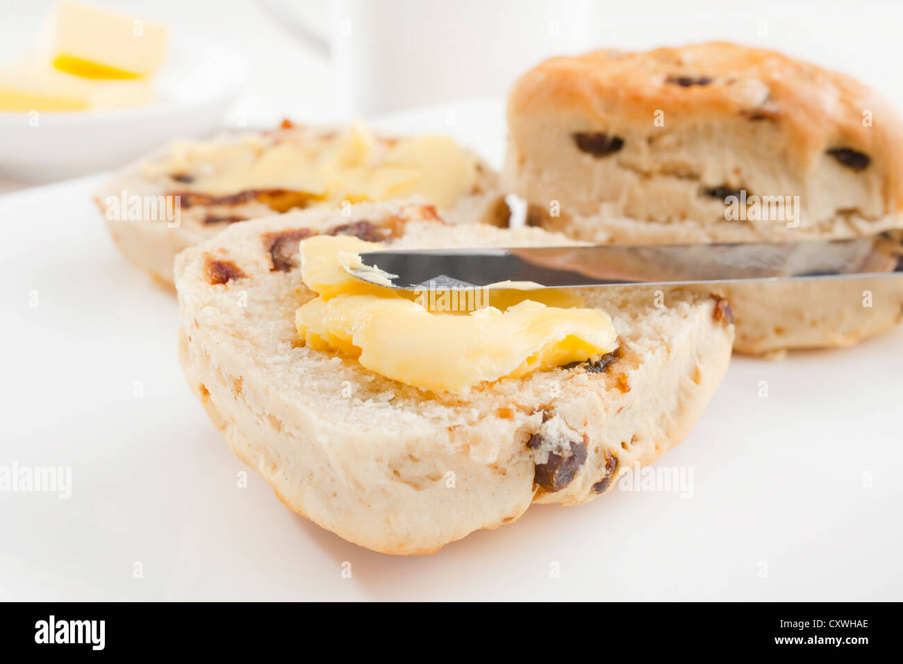 Two date scones on a white plate with butter. Stock Photo