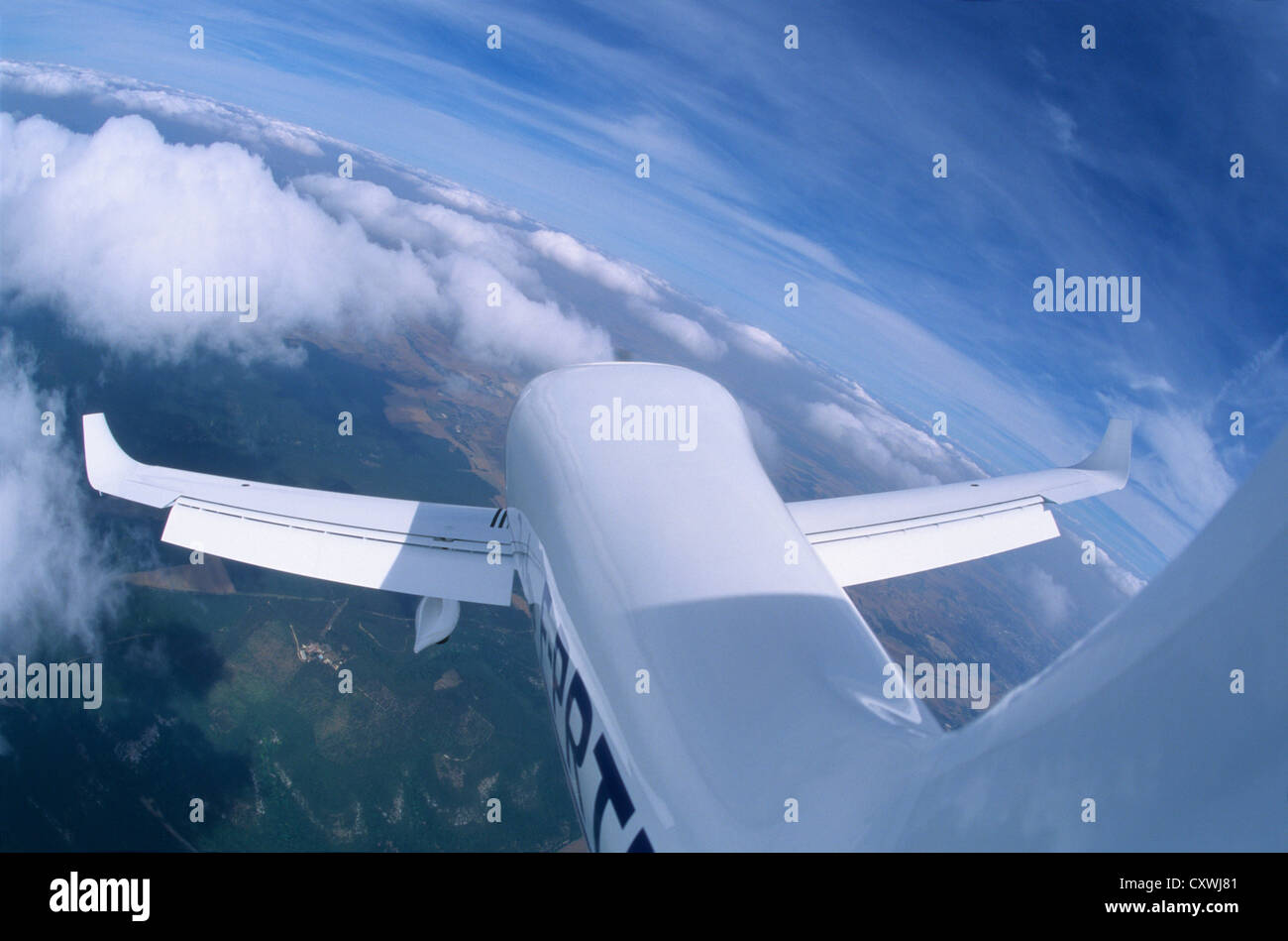 French plane Dynaero MCR-4S flying close to Cumulus clouds with full fowler flaps out, Dijon area, France Stock Photo