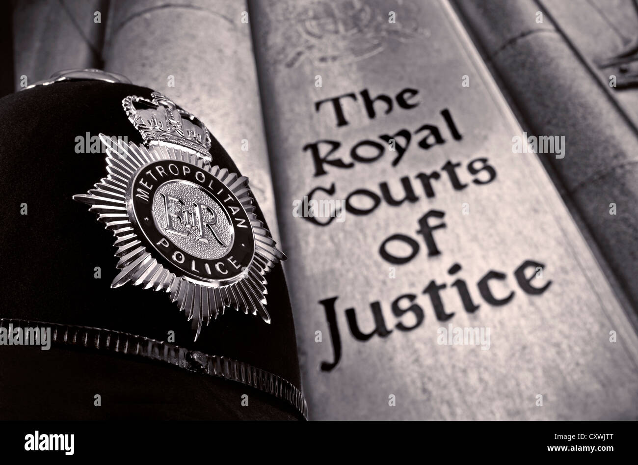 Close view on Metropolitan Police helmet with entrance sign to Royal Courts of Justice London UK  (B&W) Stock Photo