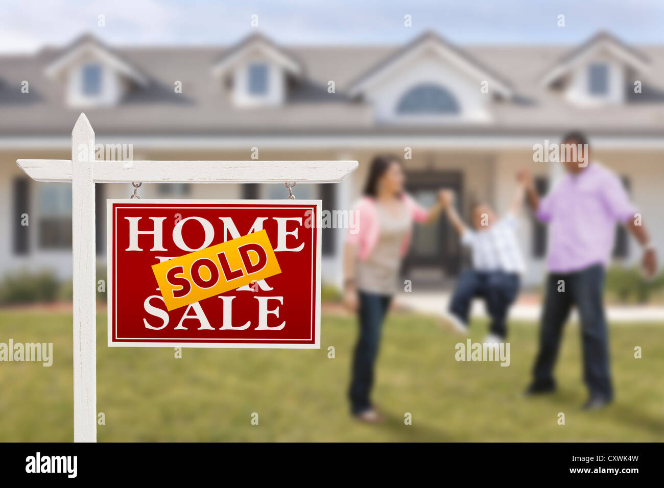 Sold Real Estate Sign and Playful Hispanic Family in Front of House ...