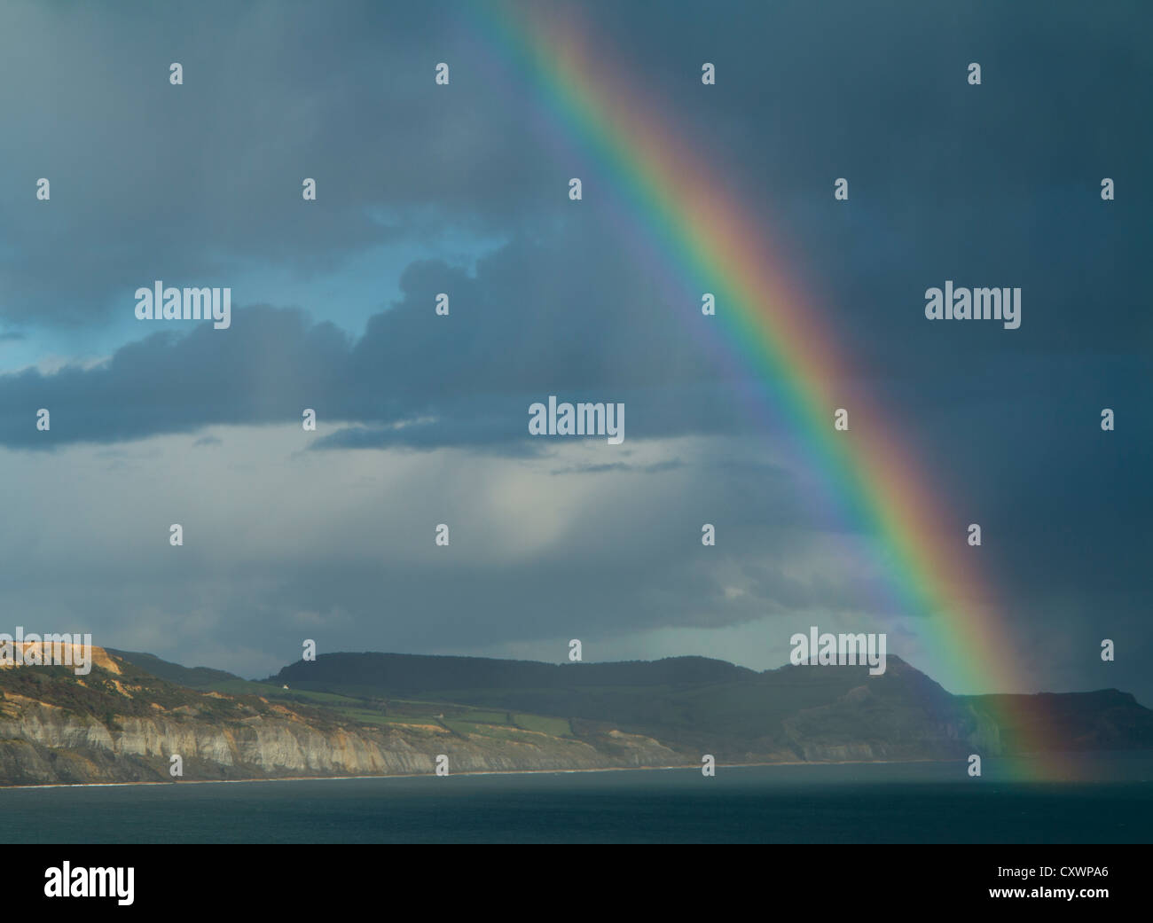 Rainbow over Lyme Bay, from Lyme Regis looking towards Golden Cap Stock Photo