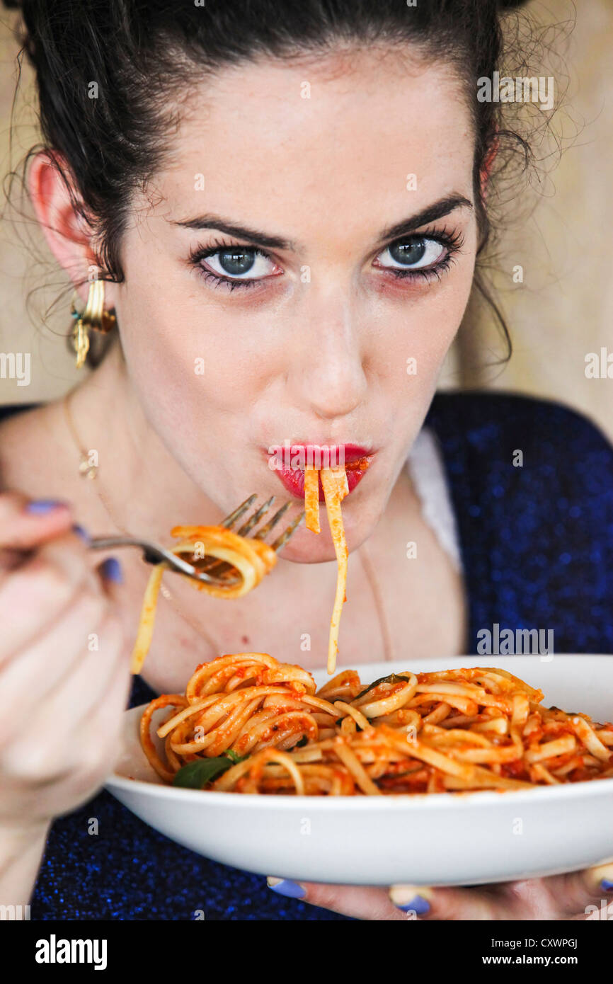 Woman eating plate of pasta Stock Photo