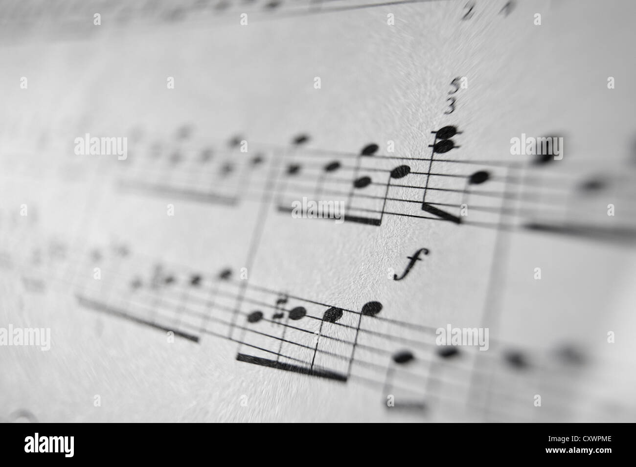 Music sheet notes score melody close up black white lines composition left right hands treble cleft printed on paper Stock Photo