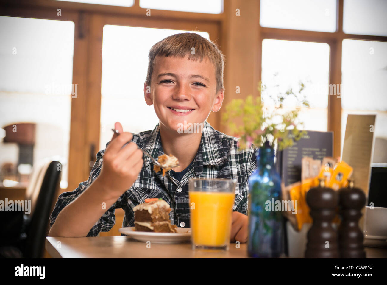Smiling boy eating breakfast at table Stock Photo