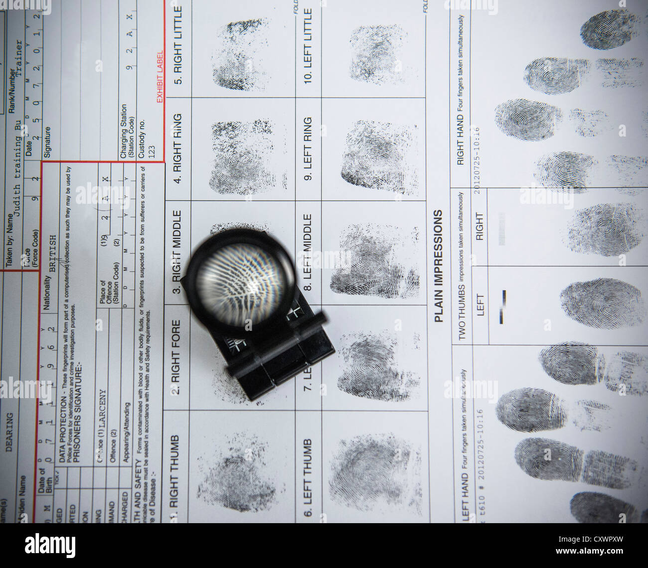 Loupe over fingerprints on arrest form Stock Photo