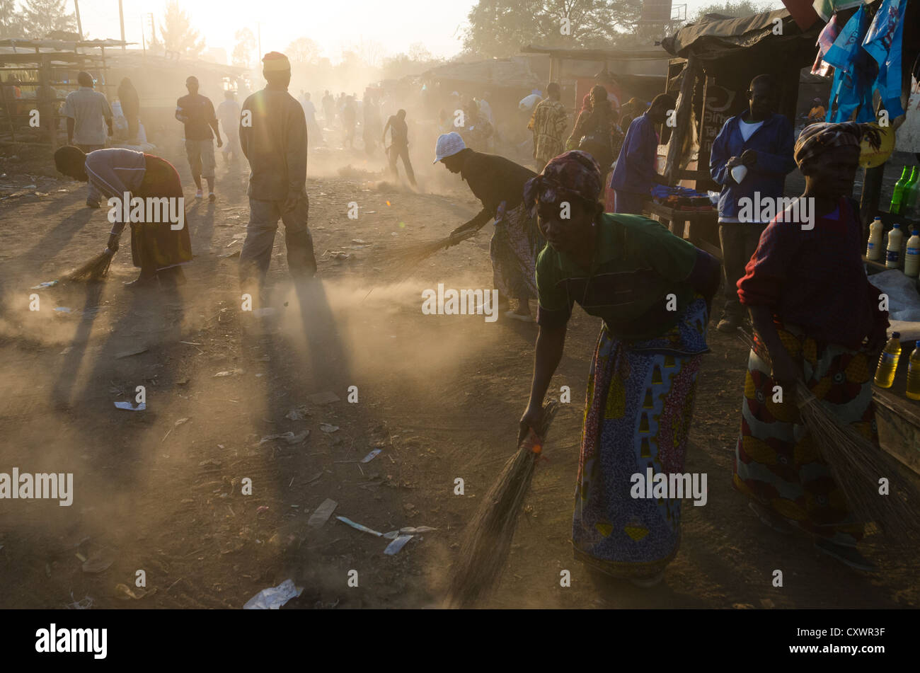 women sweeping the dust on the way to the Soweto market. Lusaka. Zambia. Stock Photo