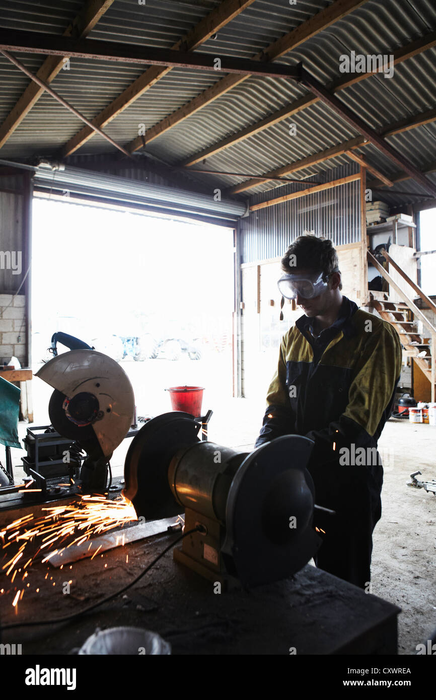 Metal worker using grinder in shop Stock Photo