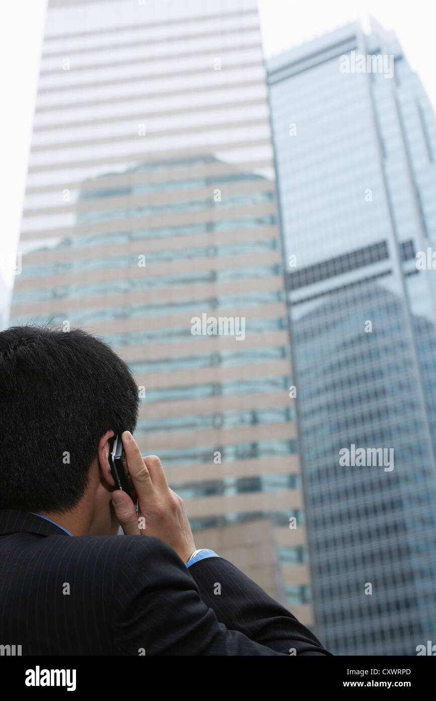 Businessman on cell phone on city street Stock Photo